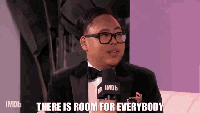a man in a tuxedo with a microphone that says imdb