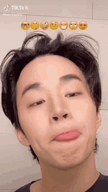 a young man is making a funny face with emojis behind him including one that says i love you