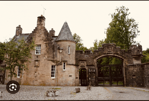 a large stone building with a castle shaped roof and a gate