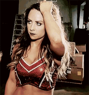 a woman in a red and white top is holding her hair