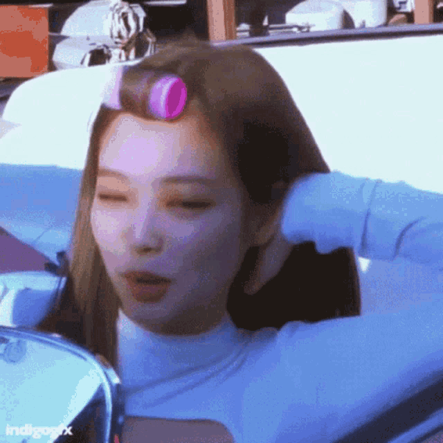 a woman is sitting in a car with rollers in her hair .
