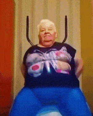 a woman in a black shirt with a butterfly on it sits on a blue ball