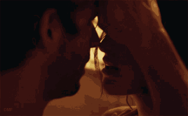 a close up of a man and woman kissing with the word dmf visible in the corner