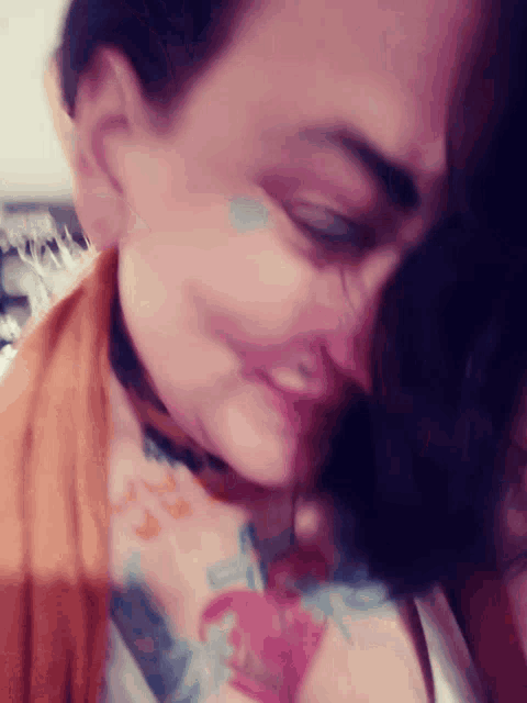 a close up of a woman 's face with a tattoo of a heart