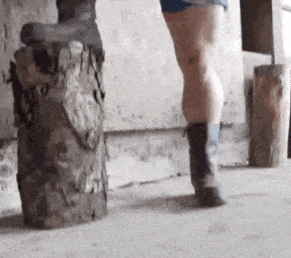 a person is standing on a tree stump with a pair of boots on .