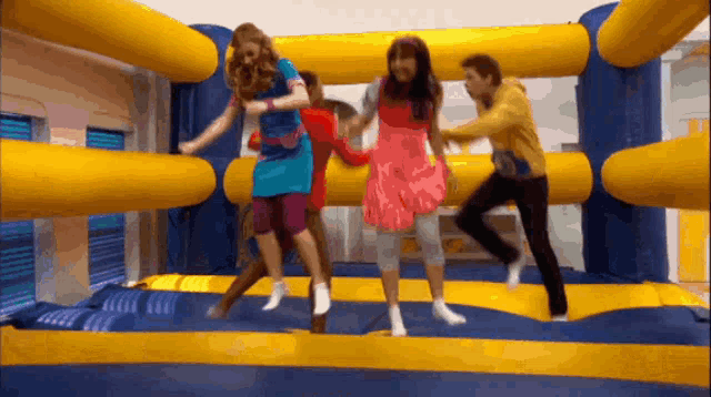 a group of kids are jumping in a bouncy house