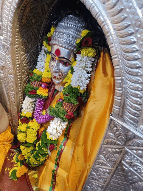 a statue of a goddess with flowers around her