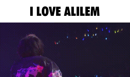 a man is singing into a microphone on a stage and the words `` i love alilem '' are above him .