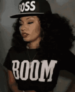 a woman wearing a black hat and a black t-shirt with the word boom on it .