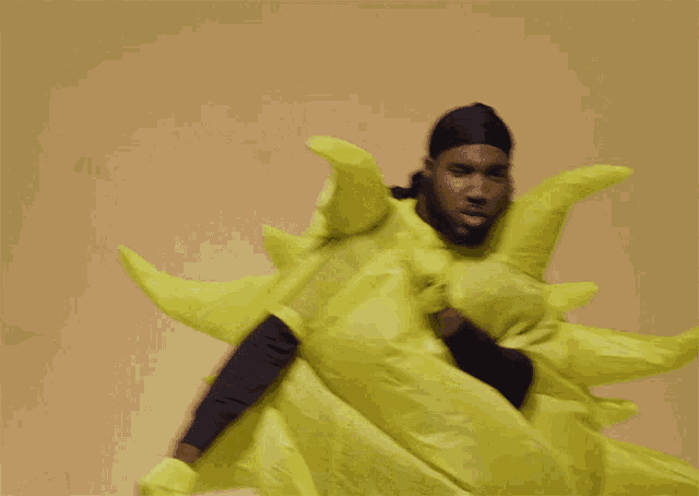 a man in a yellow sun costume is dancing