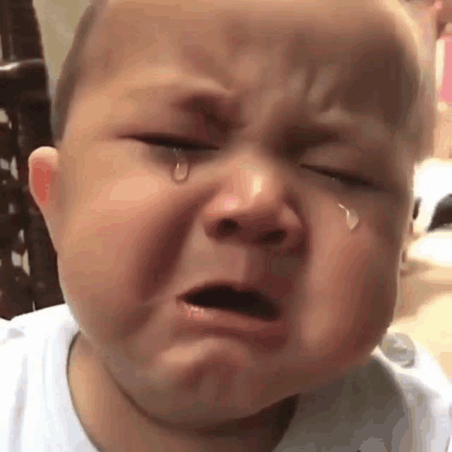 the baby is crying with a tear coming out of his nose .