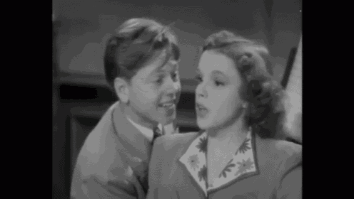 a man and a woman are looking at each other in a black and white photo