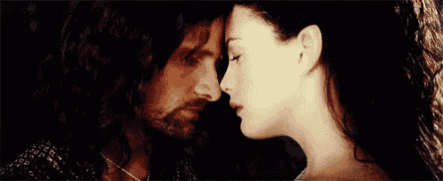 a man and a woman are looking into each other 's eyes and kissing .