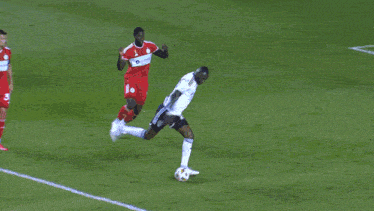a soccer goalie dives to catch the ball in front of a bodyarmor ad