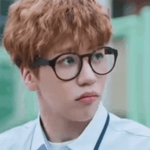 a close up of a person wearing glasses and a white shirt .