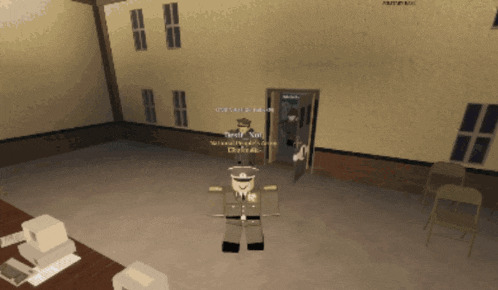 a man in a military uniform is standing in front of a door in a room with a computer and chairs