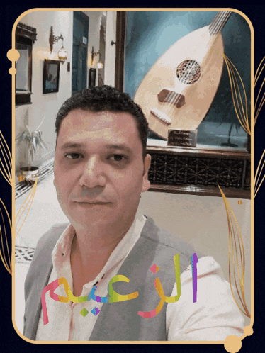 a man taking a selfie in front of a guitar with arabic writing on the bottom