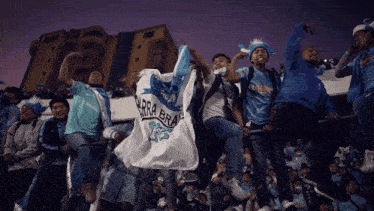 a group of people are holding a flag that says barra brava