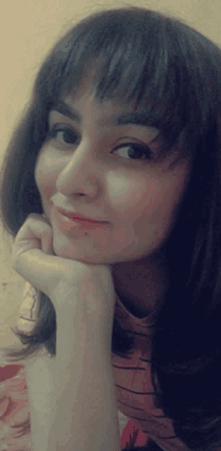 a close up of a woman 's face with a hand on her chin
