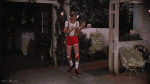 a man wearing headphones and roller skates is dancing in front of a garage door .
