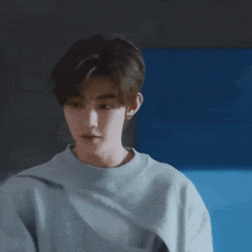 a young man wearing a grey sweater with a nike logo on it