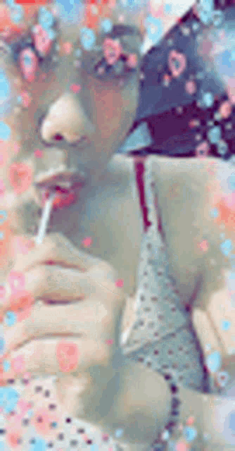 a woman is holding a lollipop in her hand and drinking from a straw .