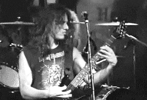 a man is playing a guitar in front of a microphone .