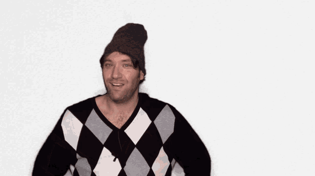 a man wearing a beanie and a sweater is making a face