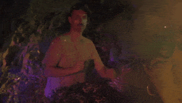 a man with a mustache is wearing a hat and a t-shirt and smoking a cigarette .