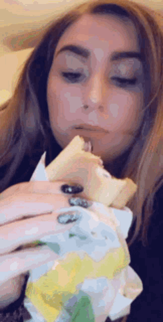 a woman is eating a subway sandwich with a fork .