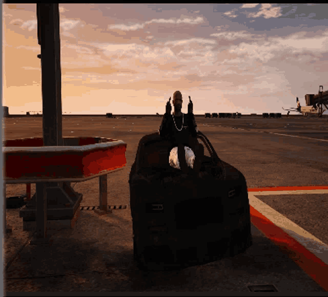 a person is sitting on a suitcase with their fingers up