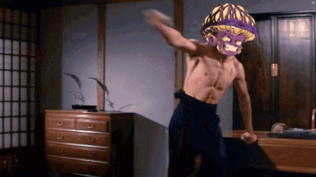 a shirtless man with a purple mask on his head