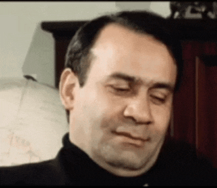 a man in a black turtleneck is making a funny face .