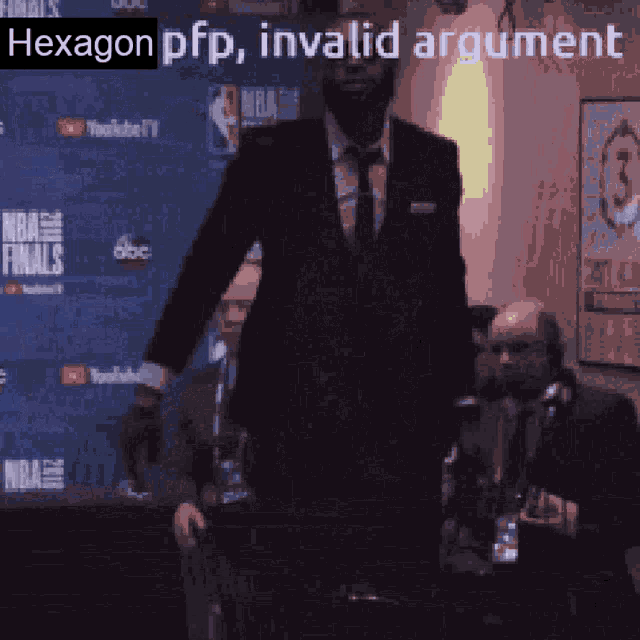 a man in a suit is standing in front of a nba finals banner