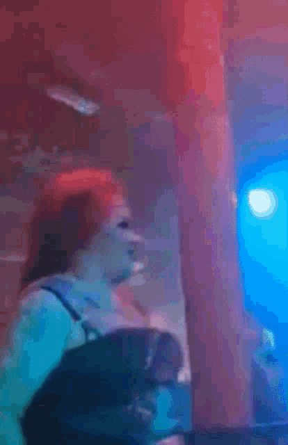 a blurry picture of a person dancing in a dark room with a blue light behind them