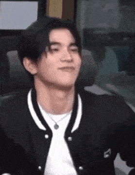 a close up of a man wearing a black jacket and a white shirt .