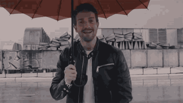 a man in a leather jacket is holding an umbrella