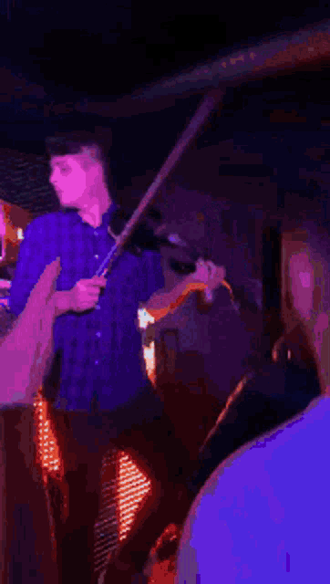 a man is playing a violin in a dark room