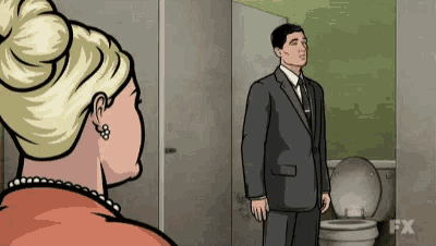a man in a suit and tie is standing in front of a toilet .