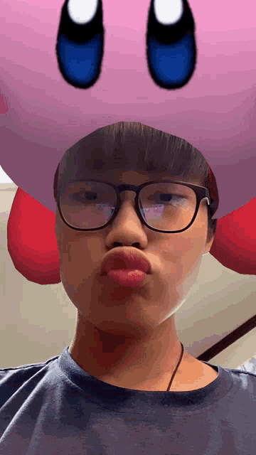 a boy wearing glasses and a kirby mask on his head