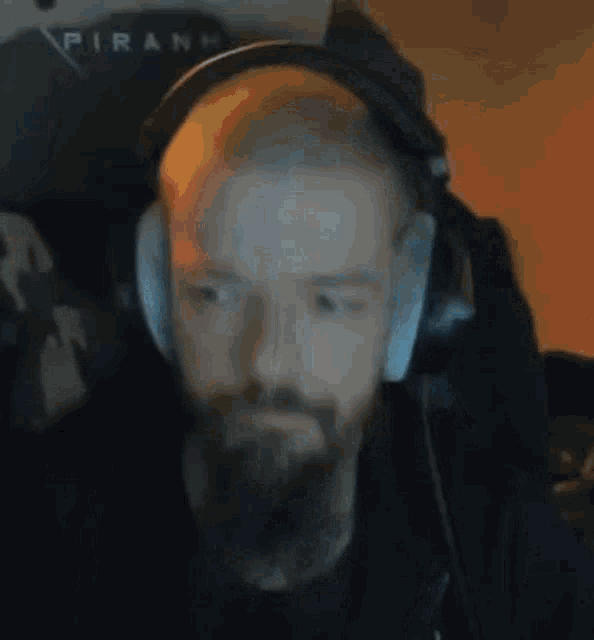 a man with a beard wearing headphones and a microphone .