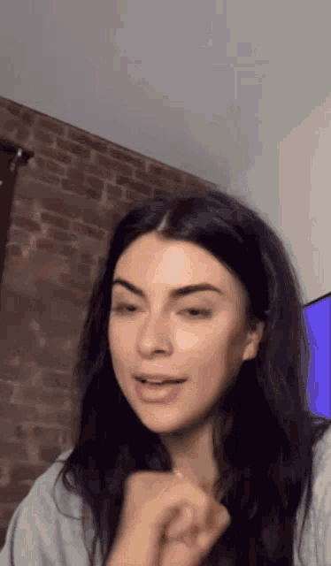 a woman with long black hair is sitting in front of a tv
