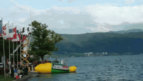 a paintball boat is floating on the water near a group of people