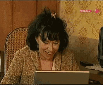 a woman is smiling while looking at a laptop with zabava written on the bottom