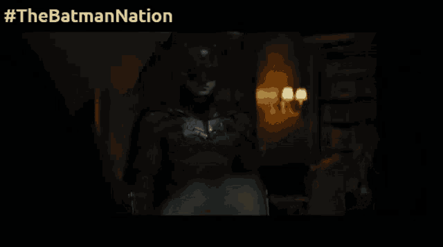 a man in a batman suit is standing next to a woman in a white shirt