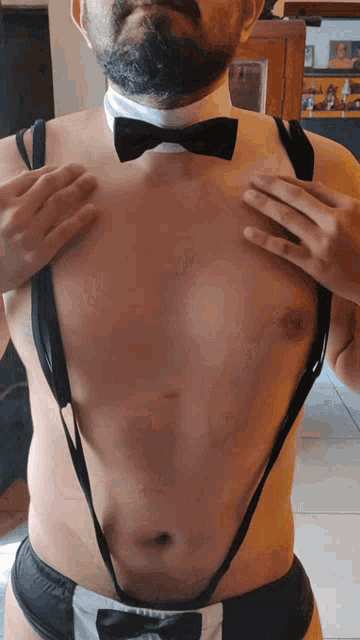 a man with a bow tie and suspenders on his chest