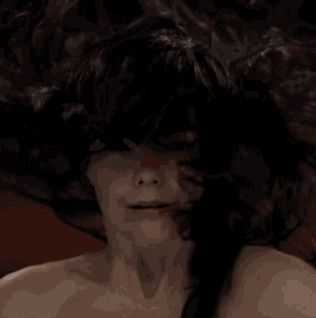 a woman without a shirt is making a funny face with her tongue out .