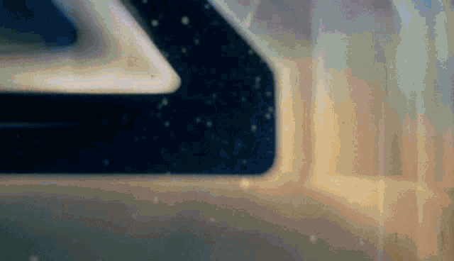 a close up of a space ship 's window with a reflection of the stars in it .