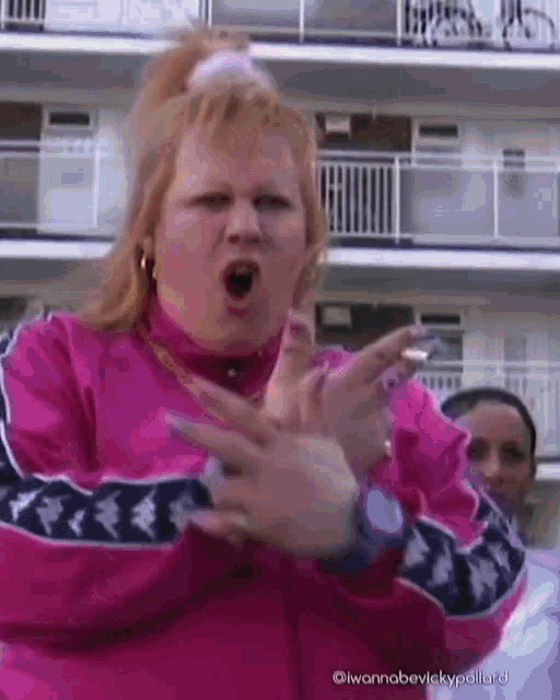 a woman in a pink jacket with kappa on the sleeves is making a funny face