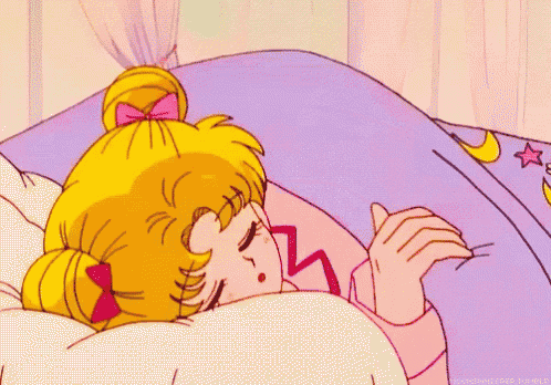 a cartoon girl is sleeping on a bed with a purple blanket and a moon and star on it .